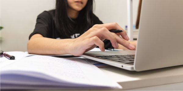 person typing at a laptop for research